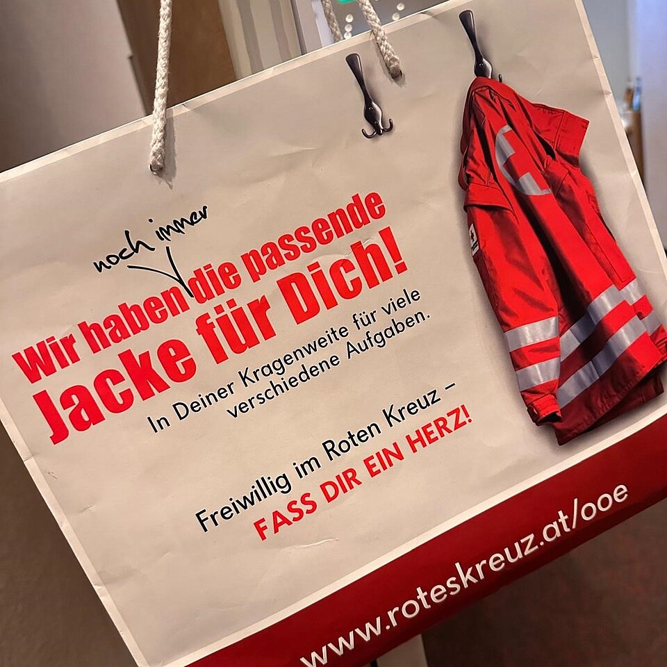 Werbung des Roten Kreuzes für Freiwillige, mit roter Jacke und Text: „Wir haben die passende Jacke für Dich!“.