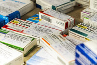 Mehrere Arzneimittelverpackungen verschiedener Medikamente liegen auf einem Tisch.