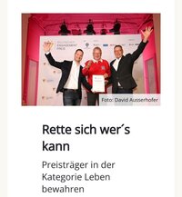 Drei Männer posieren mit einer Auszeichnung beim Deutschen Engagementpreis. Hintergrund pink beleuchtet.