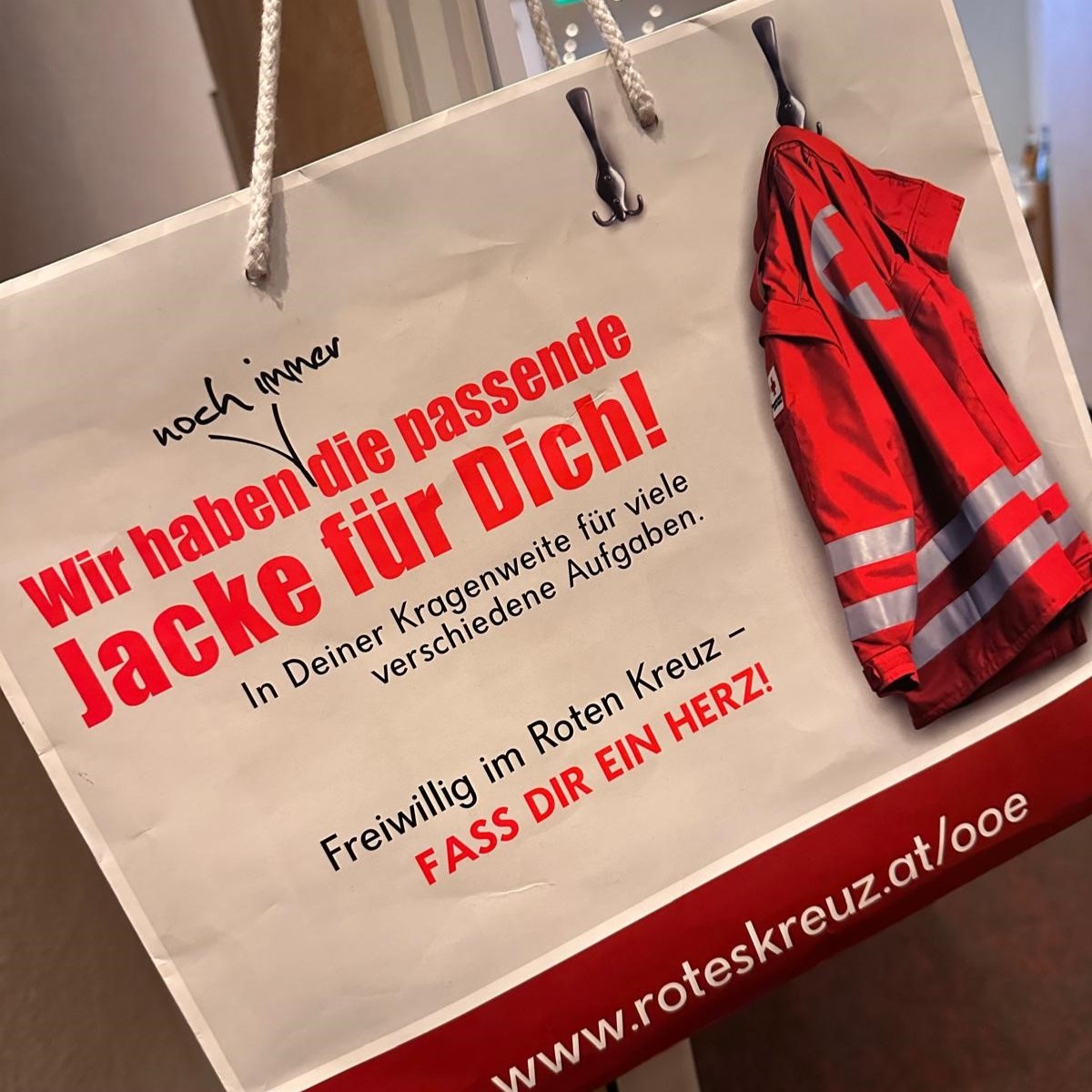 Werbung des Roten Kreuzes für Freiwillige, mit roter Jacke und Text: „Wir haben die passende Jacke für Dich!“.