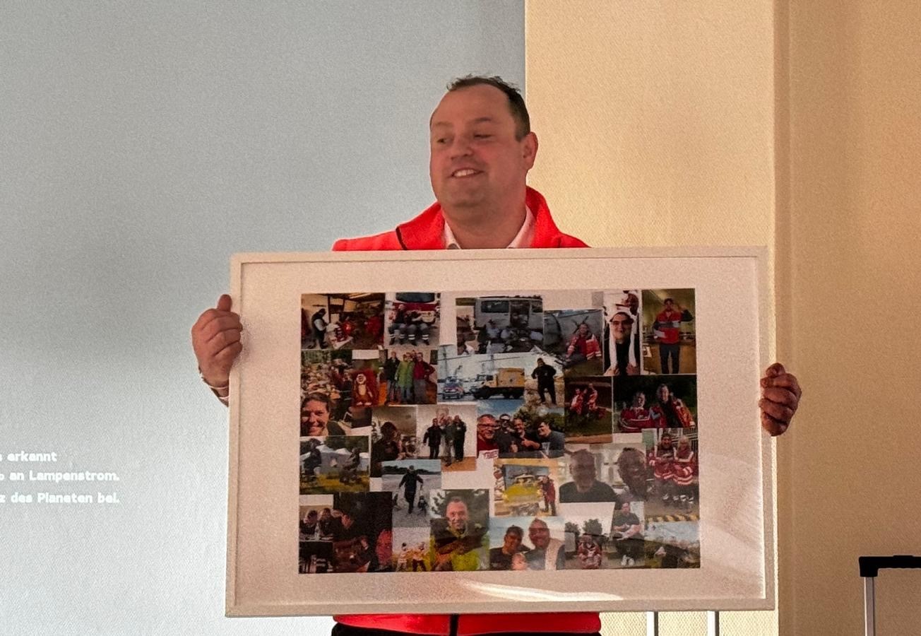 Person hält gerahmte Collage mit verschiedenen Fotos.